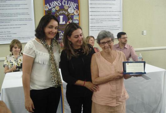 homenageada recebendo placa